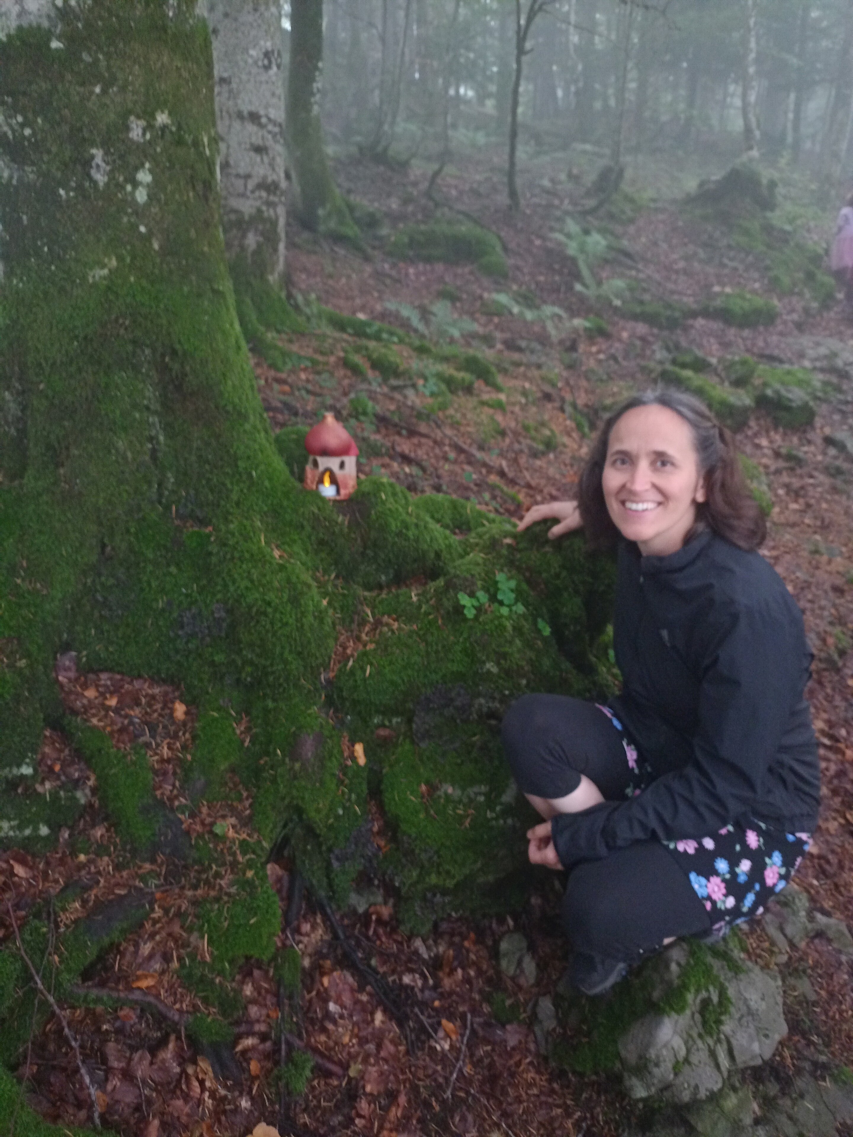 Claudia mit Elfenhaus in einer Baumwurzel